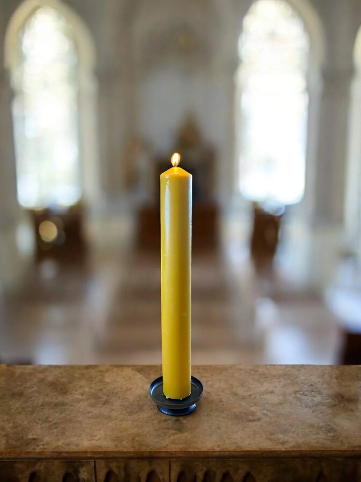 Very Large Pure Beeswax Church Candle - Hand - Poured - (37cm high) - Natural Honey Scent - Minimum 100 hours burntime  on an alter with a church in the background- Mêl Llŷn